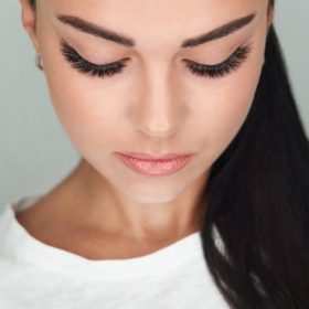 girl with extended silk eyelashes and eyes closed in a beauty studio